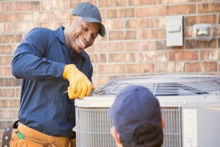 Picture of two HVAC Contractors completing repairs of the AC unit