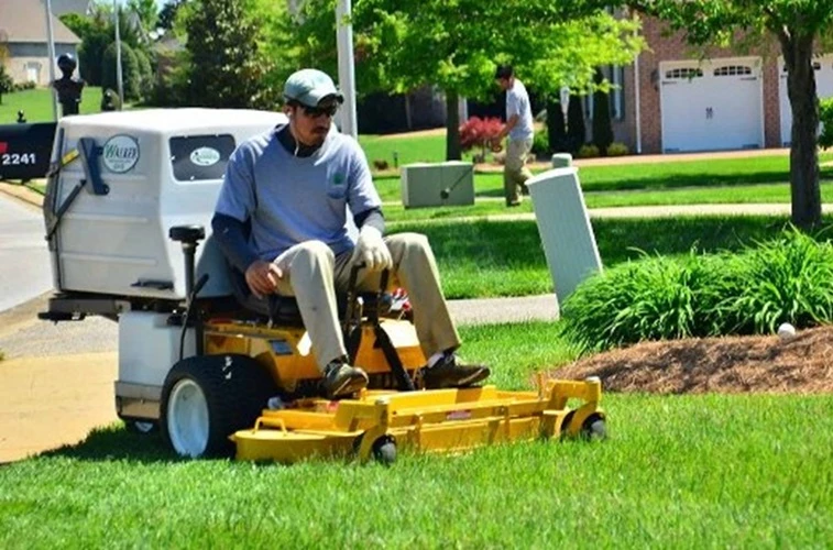 Picture of 4 Landscape Contractors cleaning and maintaining the flower beds