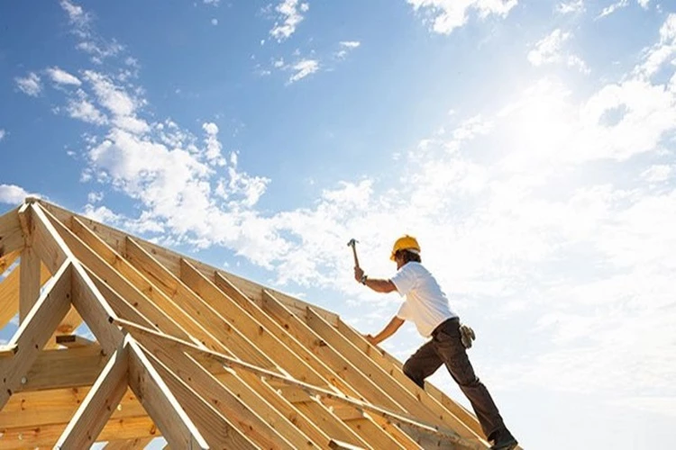 Picture of a Roofing Contractor installing the last rafter on the home